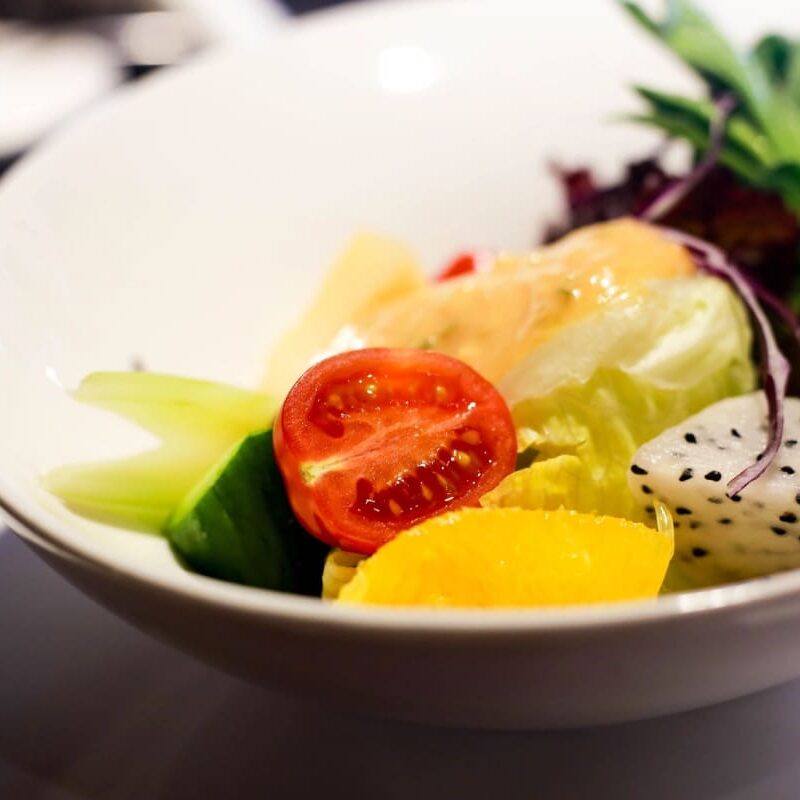 A bowl of salad with tomatoes, lettuce and cucumber.